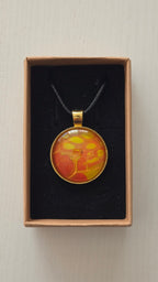 Runde Cabochon Kette Solas Golden Heat mit abstraktem Muster in Orange, Gelb und Gold, goldfarbener Fassung und schwarzem Band.
