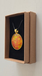 Runde Cabochon Kette Solas Golden Heat mit abstraktem Muster in Orange, Gelb und Gold, goldfarbener Fassung und schwarzem Band.