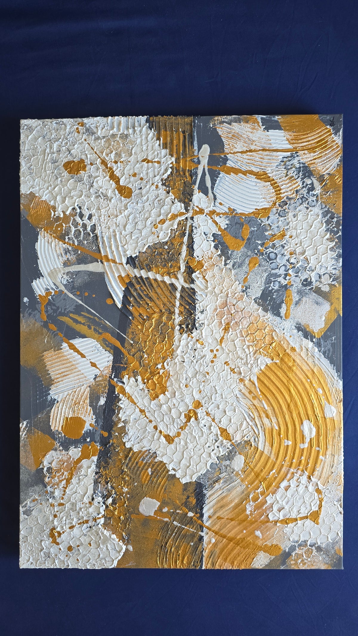 Zwei versetzt angeordnete abstrakte Strukturbilder in Gold, Weiss und Grau mit erhabenen Flächen, geschwungenen Linien und kreisförmigen Mustern.