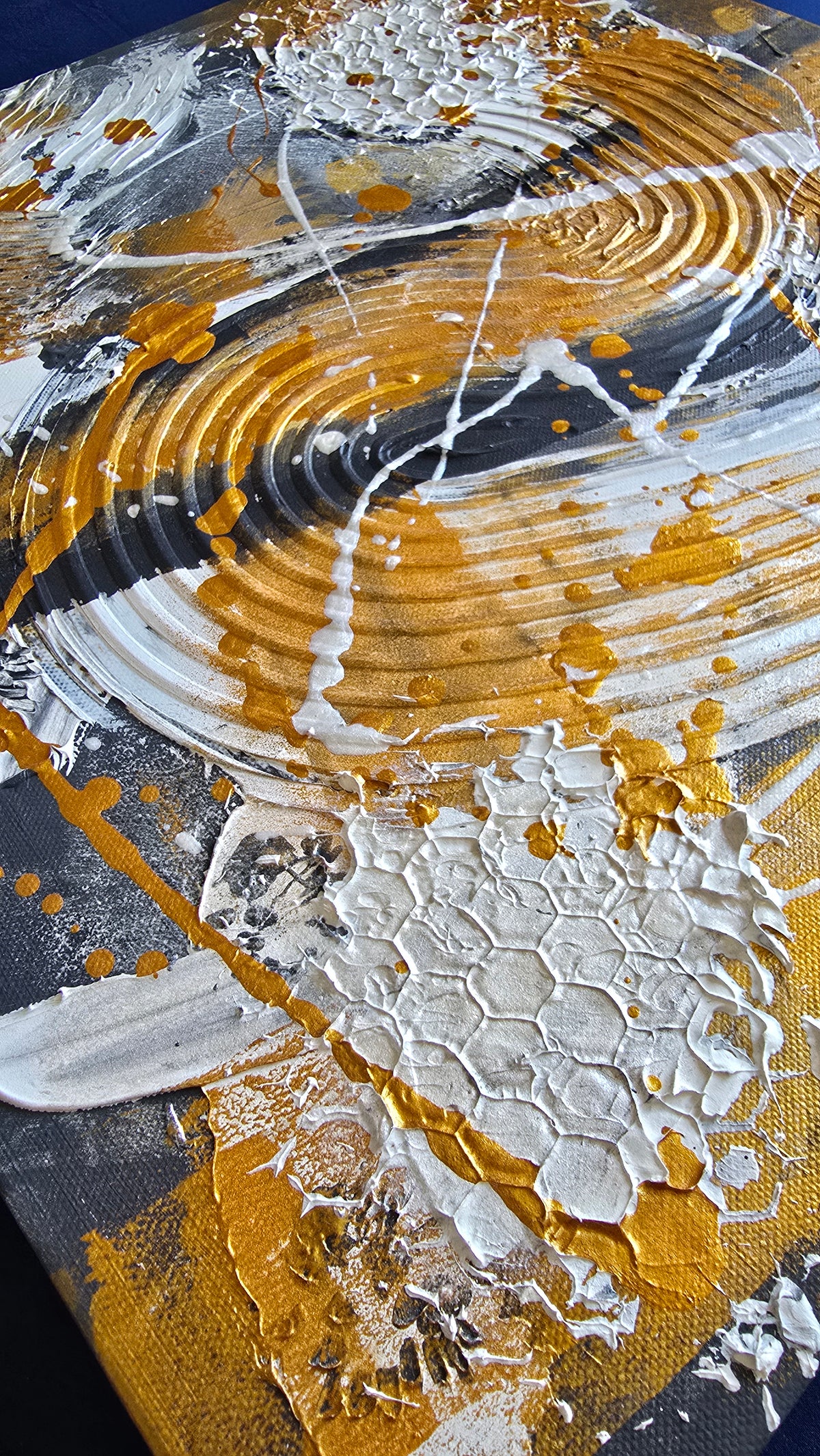 Zwei versetzt angeordnete abstrakte Strukturbilder in Gold, Weiss und Grau mit erhabenen Flächen, geschwungenen Linien und kreisförmigen Mustern.