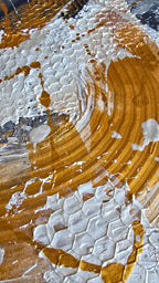 Zwei versetzt angeordnete abstrakte Strukturbilder in Gold, Weiss und Grau mit erhabenen Flächen, geschwungenen Linien und kreisförmigen Mustern.