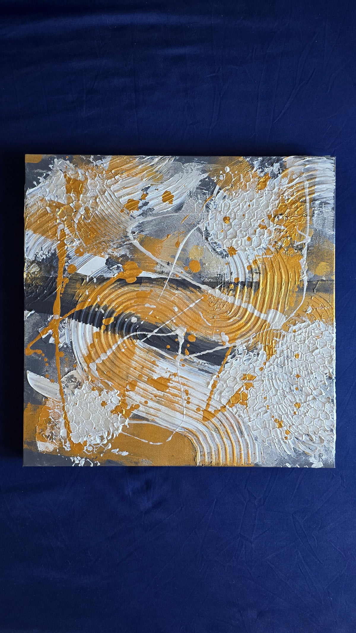 Zwei versetzt angeordnete abstrakte Strukturbilder in Gold, Weiss und Grau mit erhabenen Flächen, geschwungenen Linien und kreisförmigen Mustern.