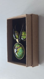 Rundes Cabochon-Schmuckset mit grossem Halskettenanhänger und zwei passenden Ohrringen in Grün und Limette mit dunklen organischen Konturen.
