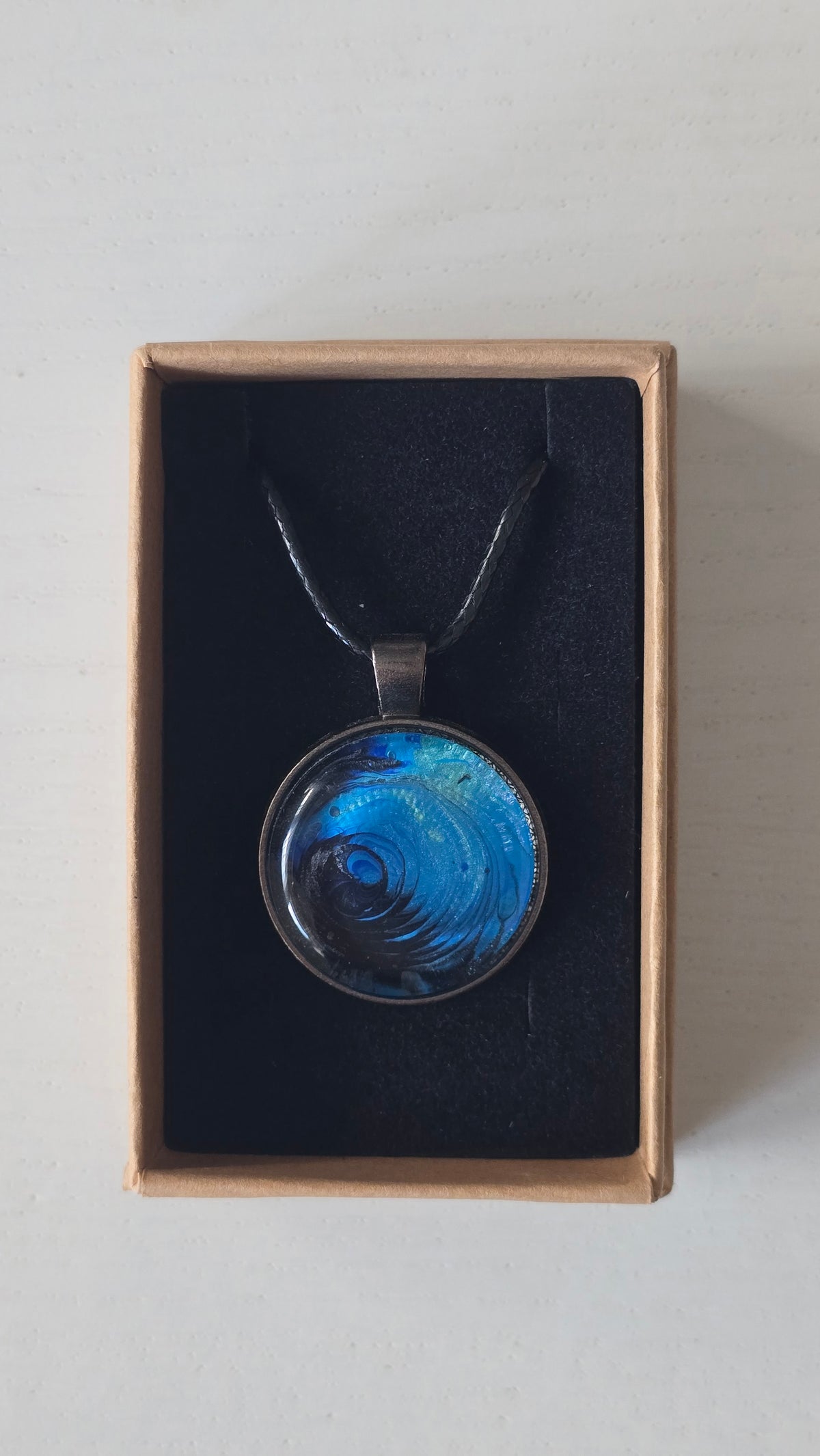 Runde Cabochon-Kette mit spiralförmigem Ozeanmuster in leuchtendem Türkis, kräftigem Blau und dunklem Tiefblau.
