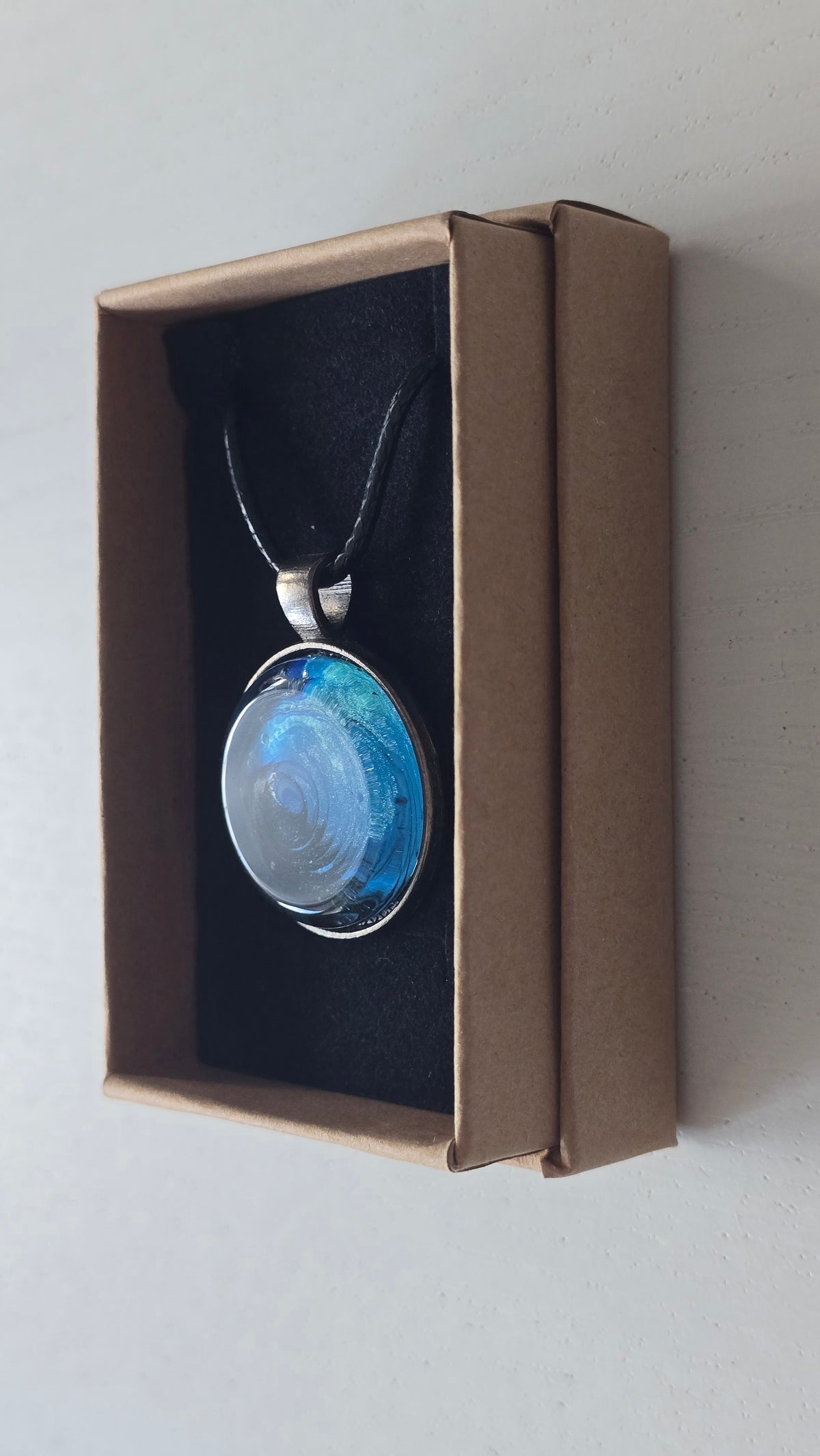 Runde Cabochon-Kette mit spiralförmigem Ozeanmuster in leuchtendem Türkis, kräftigem Blau und dunklem Tiefblau.