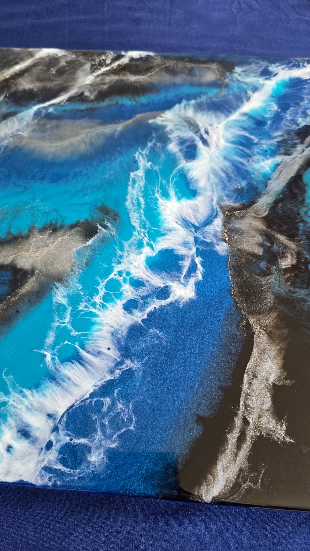 Abstraktes Resin Wandbild Solas Liquid Azure in Blau, Türkis, Schwarz und Silber mit weissen fliessenden Formen und irisierenden Details.