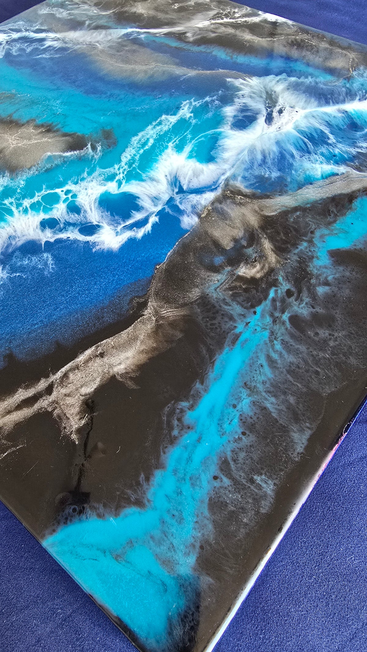 Abstraktes Resin Wandbild Solas Liquid Azure in Blau, Türkis, Schwarz und Silber mit weissen fliessenden Formen und irisierenden Details.