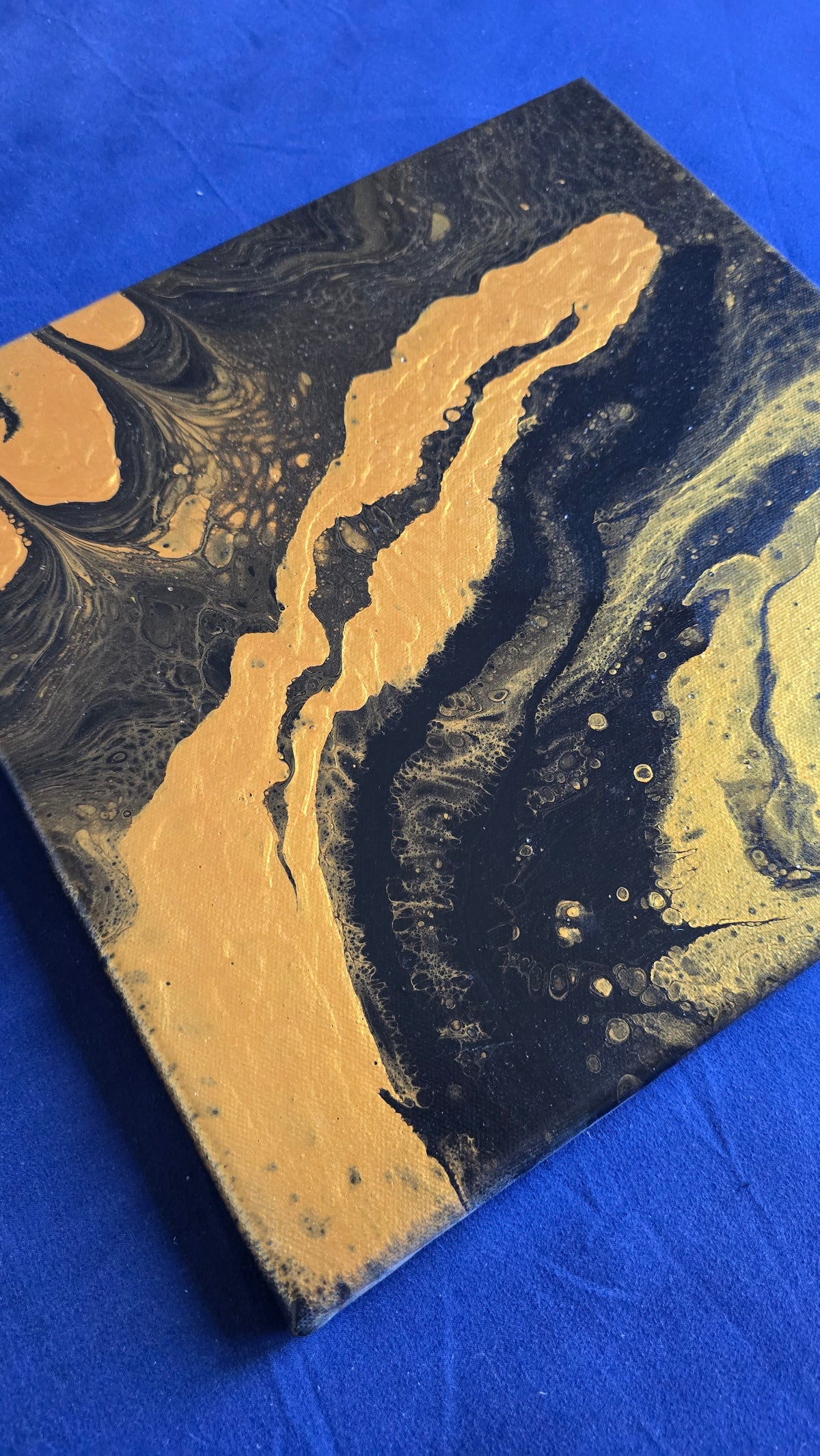 Zwei quadratische abstrakte Acryl-Leinwandbilder mit fliessenden Strukturen in Dunkelblau, Gold und feinen hellen Akzenten.