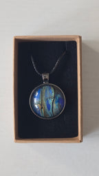 Runde Cabochon Kette Solas Ocean Veil in Blau, Türkis, Petrol und Grün mit dunkler Metallfassung und schwarzem Band.