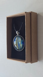 Runde Cabochon Kette Solas Ocean Veil in Blau, Türkis, Petrol und Grün mit dunkler Metallfassung und schwarzem Band.