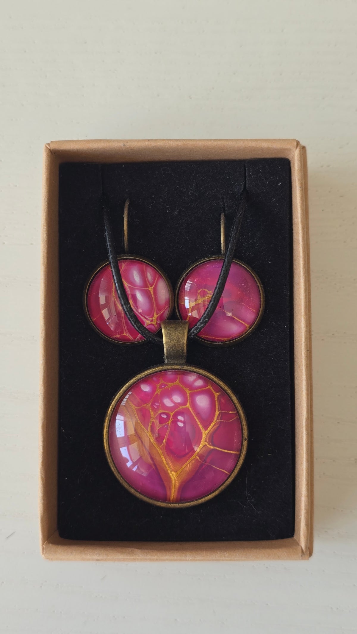 Handgefertigtes Schmuckset Solas Pink Dream mit runder Halskette und passenden Ohrringen in leuchtenden Pink-, Magenta- und Goldtönen mit fließender Marmorierung.