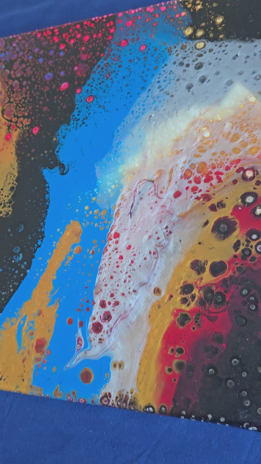 Drei abstrakte Leinwandbilder in unterschiedlichen Grössen mit fliessenden Farbflächen und feinen Zellstrukturen in Rot, Blau, Gold, Schwarz und Weiss.