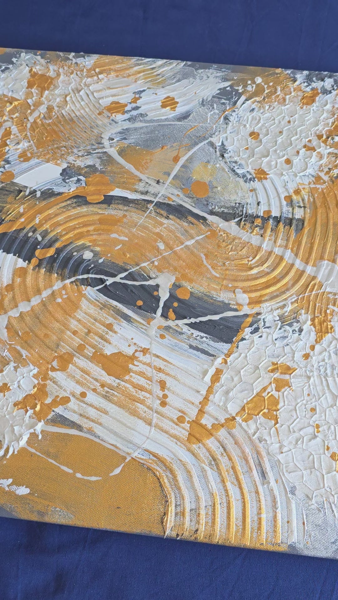 Zwei versetzt angeordnete abstrakte Strukturbilder in Gold, Weiss und Grau mit erhabenen Flächen, geschwungenen Linien und kreisförmigen Mustern.