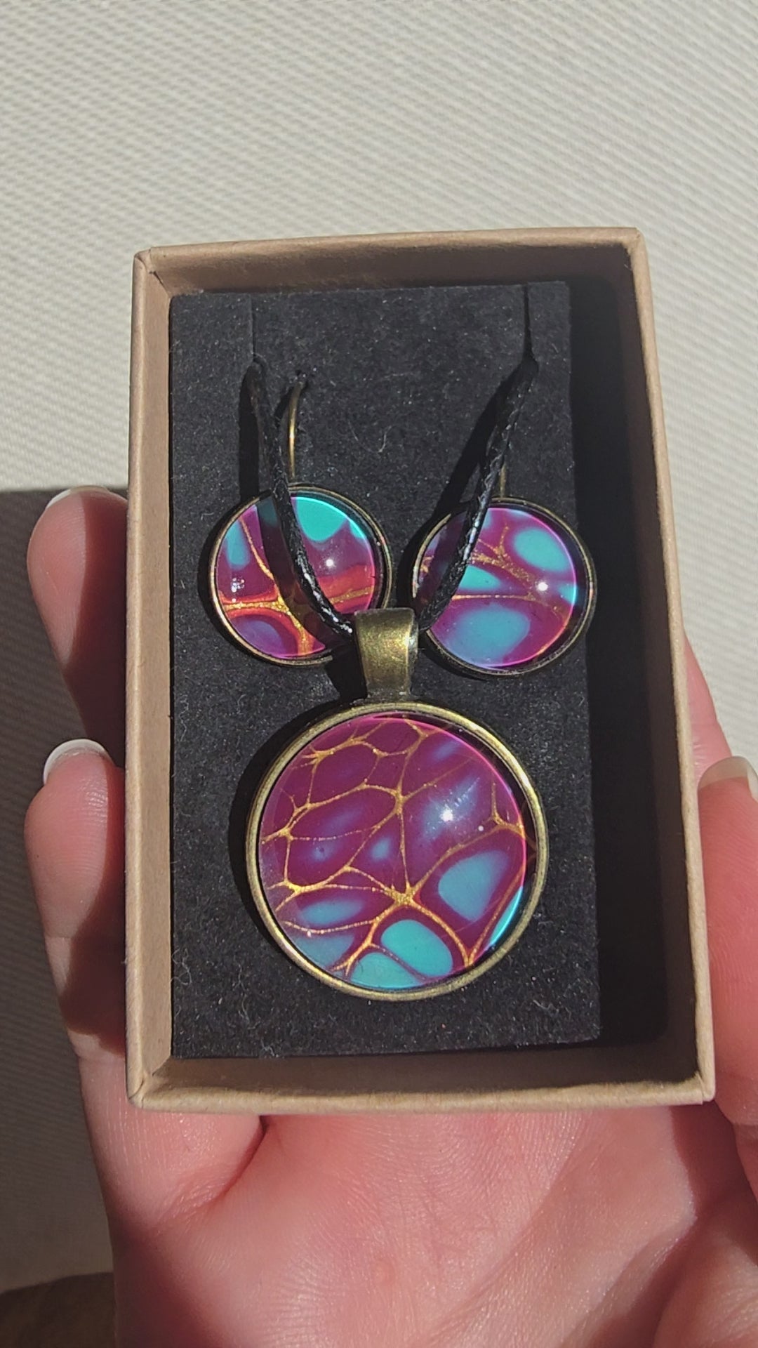 Handgefertigtes Schmuckset Solas Golden Spikes mit runder Halskette und passenden Ohrringen in Violett-, Türkis- und Goldtönen mit markanten goldenen Linien.