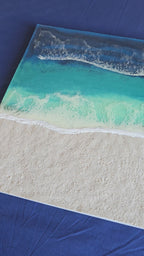 Handgefertigtes quadratisches resin gessobild mit türkisblauem Meer, weissen Wellen und strukturierter Sandfläche. Modernes Meeresbild als Unikat von Solas Artwork.