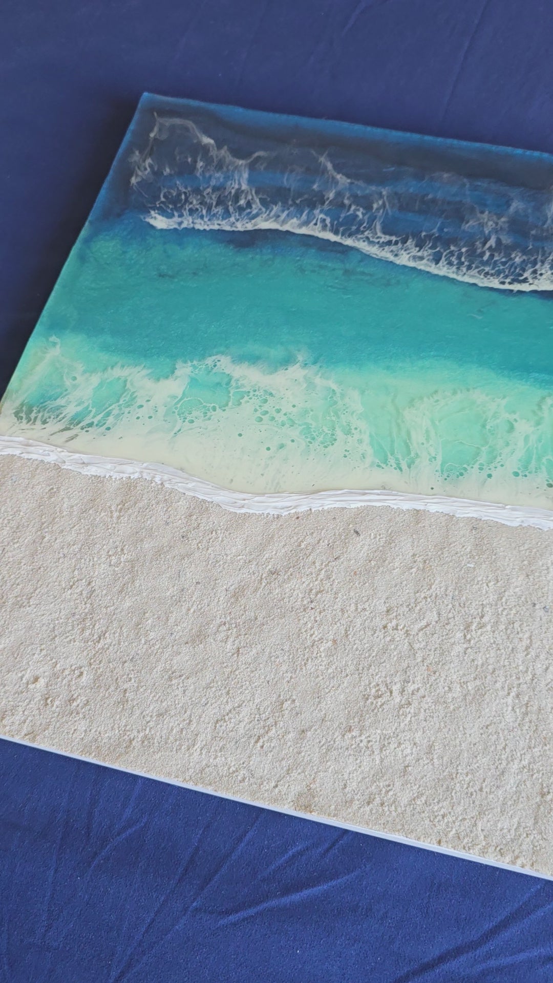 Handgefertigtes quadratisches resin gessobild mit türkisblauem Meer, weissen Wellen und strukturierter Sandfläche. Modernes Meeresbild als Unikat von Solas Artwork.