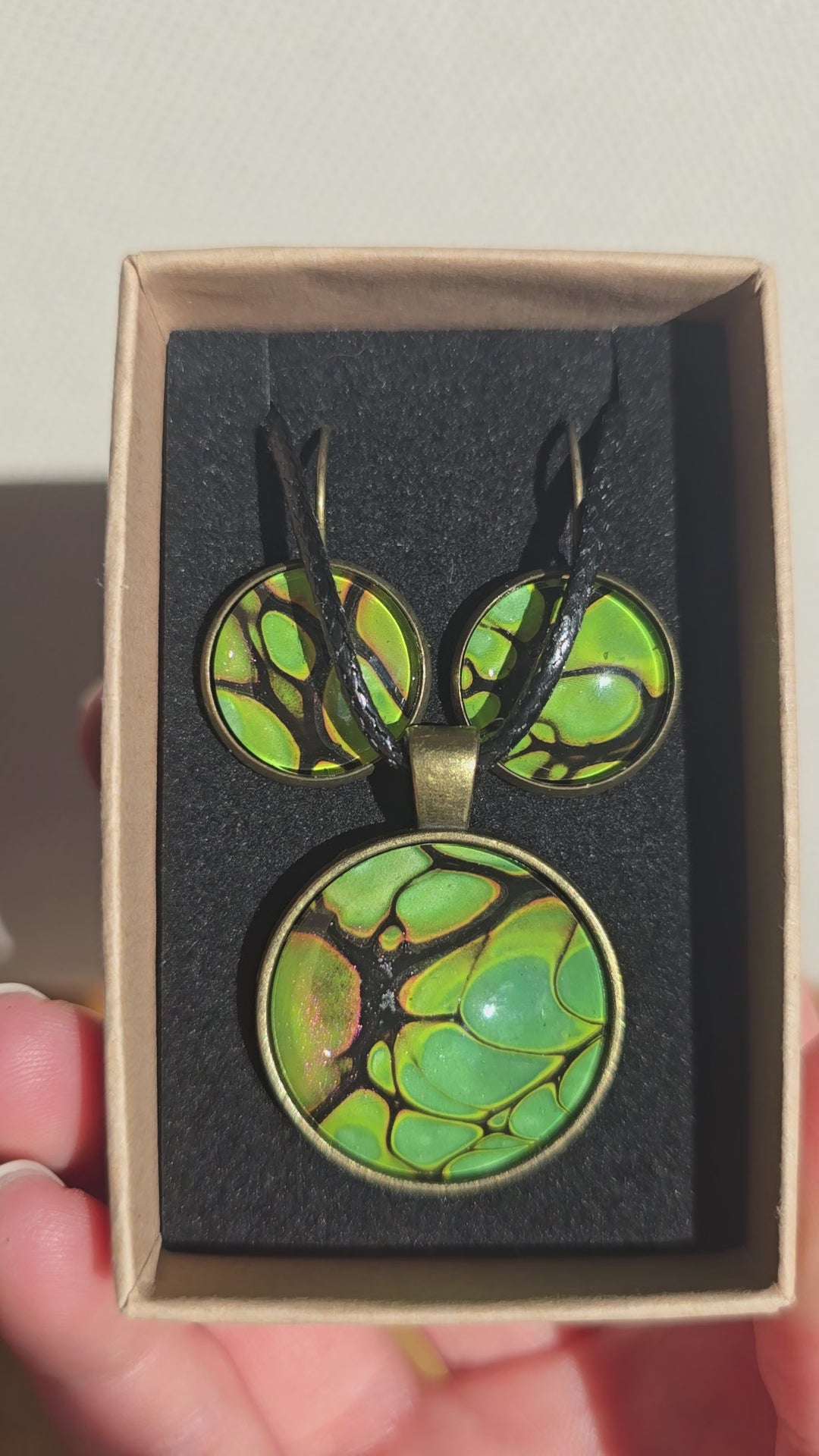 Rundes Cabochon-Schmuckset mit grossem Halskettenanhänger und zwei passenden Ohrringen in Grün und Limette mit dunklen organischen Konturen.