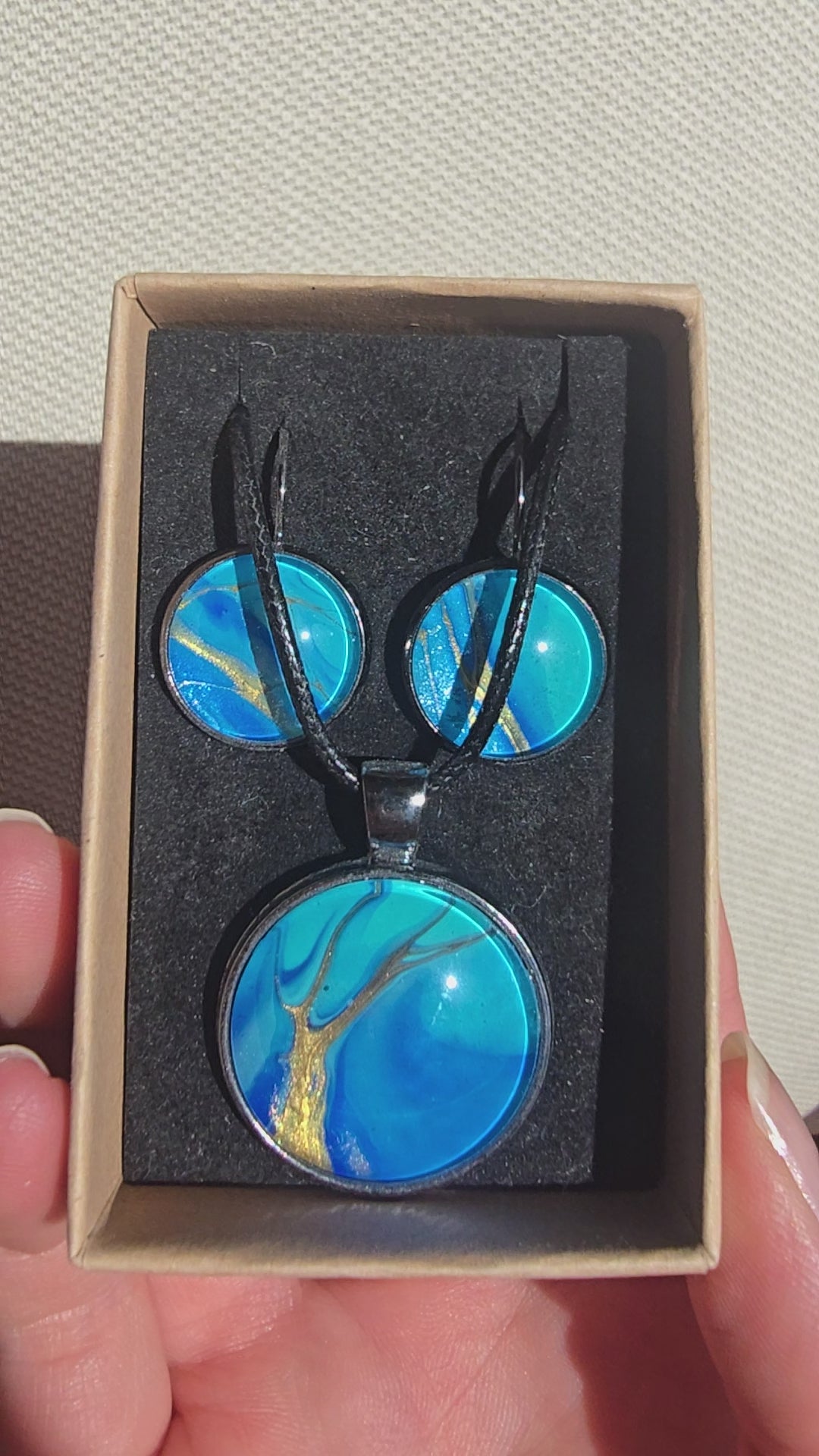 Handgefertigtes Schmuckset Solas Tide mit runder Halskette und passenden Ohrringen in Türkis-, Blau- und goldenen Farbtönen mit fließender Marmorierung.