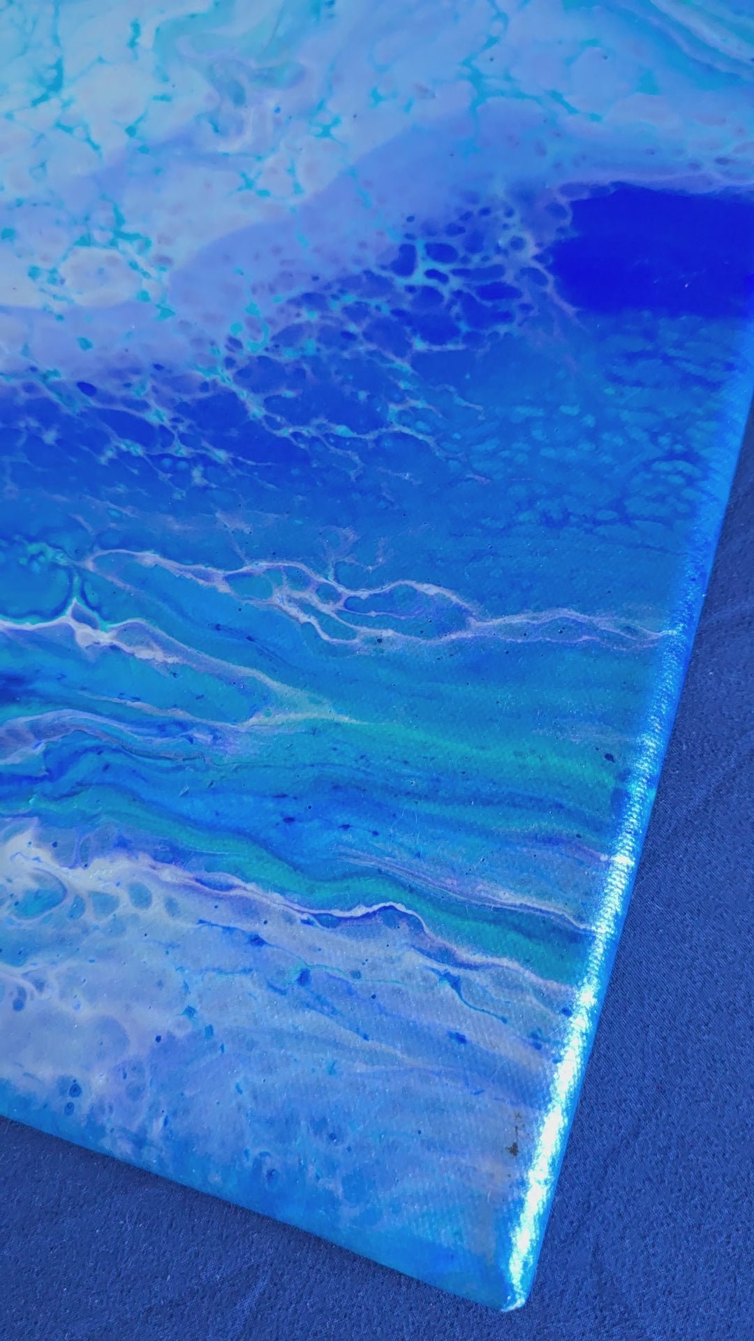Quadratisches abstraktes Leinwandbild in Weiss, Hellblau, Türkis und kräftigem Blau mit fliessenden, wolkenartigen Strukturen.