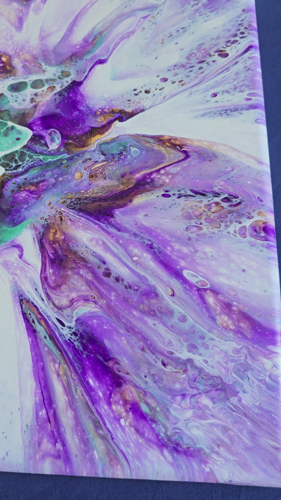 Fünf abstrakte Leinwandbilder in unterschiedlichen Grössen mit fliessenden Strukturen in Violett, Türkis, Weiss sowie Gold- und Bronzeakzenten.