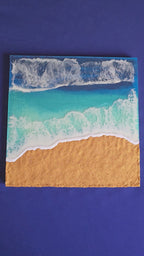 Handgefertigtes Resin-Meeresbild «Solas Shoreline» mit türkisfarbenem Wasser, schäumender Brandung und strukturiertem goldenen Strand auf einem 40 × 40 cm Gesso-Rahmen.