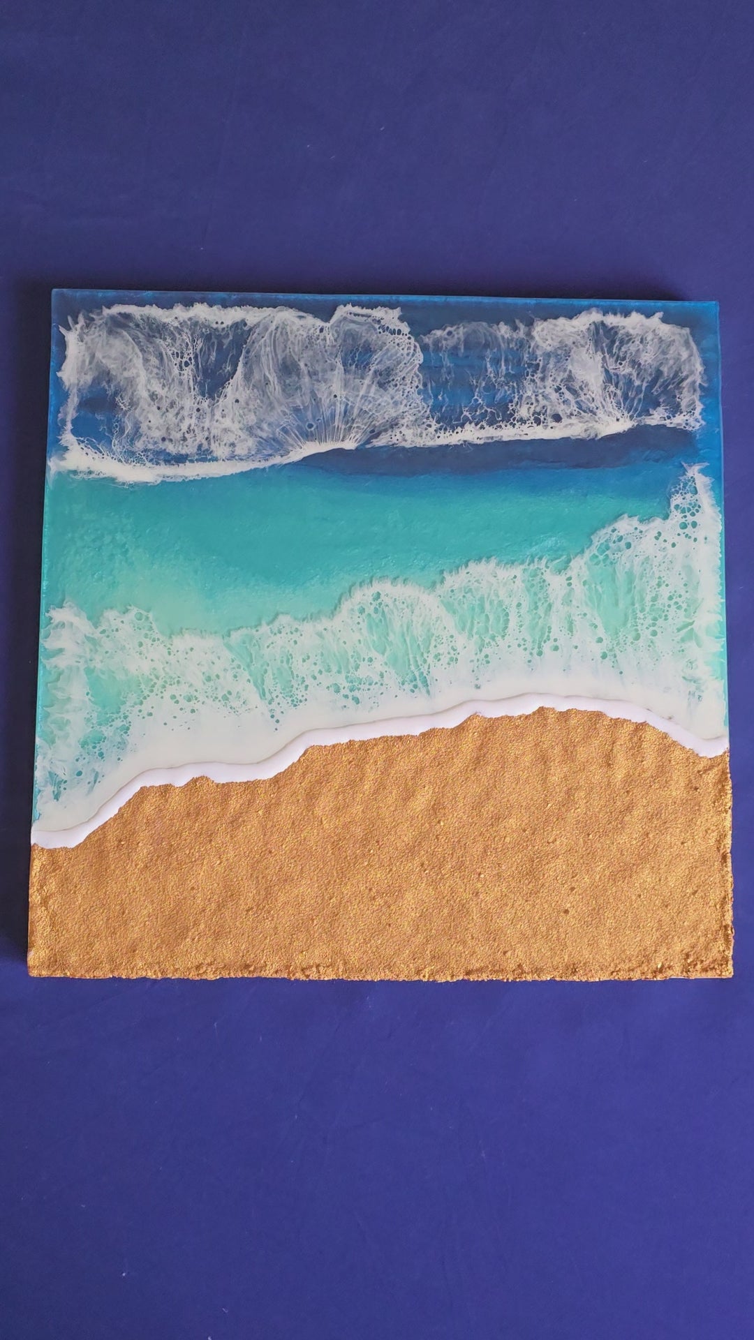 Handgefertigtes Resin-Meeresbild «Solas Shoreline» mit türkisfarbenem Wasser, schäumender Brandung und strukturiertem goldenen Strand auf einem 40 × 40 cm Gesso-Rahmen.
