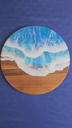 Rundes Resin Wandbild Solas Seafoam auf Holz mit blau-türkisem Meer, weissen Wellen, irisierenden Farbakzenten und sichtbarer Holzstruktur.