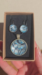 Rundes Cabochon-Schmuckset mit Anhänger und Ohrringen an schwarzem Band, mit marmoriertem Muster in Blau, Cyan, Silber-/Perlgrau, Anthrazit und Schwarz.