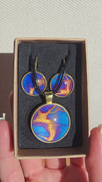 Handgefertigtes Schmuckset Solas Golden Dawn mit runder Halskette und passenden Ohrringen in Blau-, Violett- und Goldtönen mit fliessender Marmorierung.