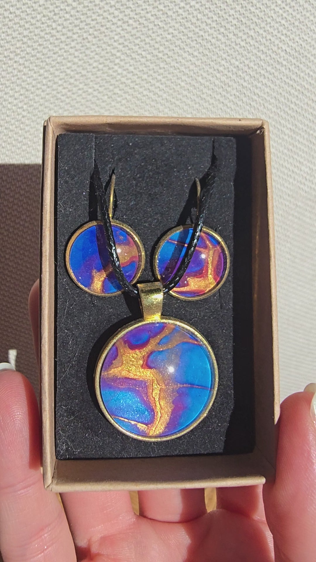 Handgefertigtes Schmuckset Solas Golden Dawn mit runder Halskette und passenden Ohrringen in Blau-, Violett- und Goldtönen mit fliessender Marmorierung.