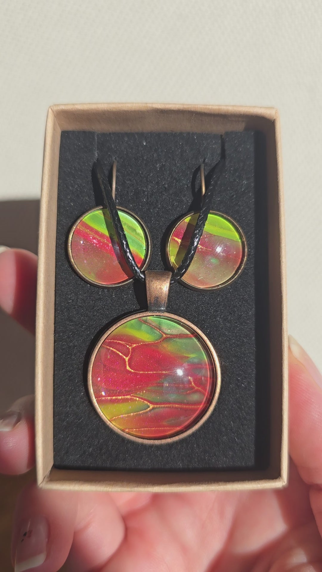 Rundes Cabochon-Schmuckset mit grossem Halskettenanhänger und zwei passenden Ohrringen in Rot, Grün und Gelb mit kupfer-goldenen Linien.