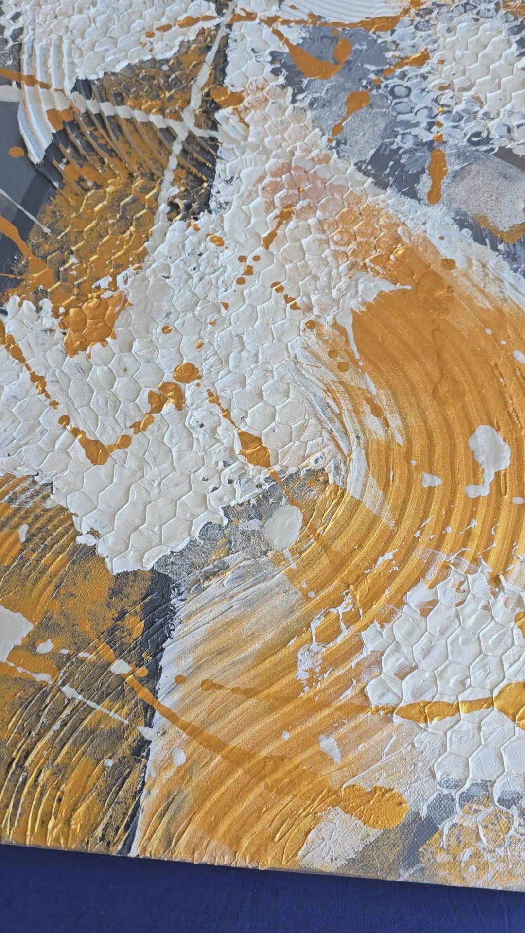 Zwei versetzt angeordnete abstrakte Strukturbilder in Gold, Weiss und Grau mit erhabenen Flächen, geschwungenen Linien und kreisförmigen Mustern.