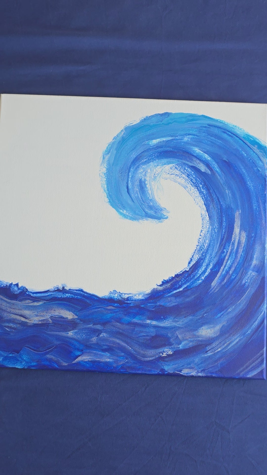 Quadratisches Acryl-Leinwandbild mit grosser geschwungener Meereswelle in verschiedenen kräftigen Blautönen auf weissem Hintergrund.
