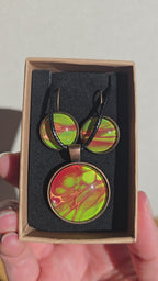Rundes Cabochon-Schmuckset mit Kette und zwei Ohrringen in leuchtendem Grün, Korallrot und Orange, mit feinen kupferfarbenen, organischen Linien.