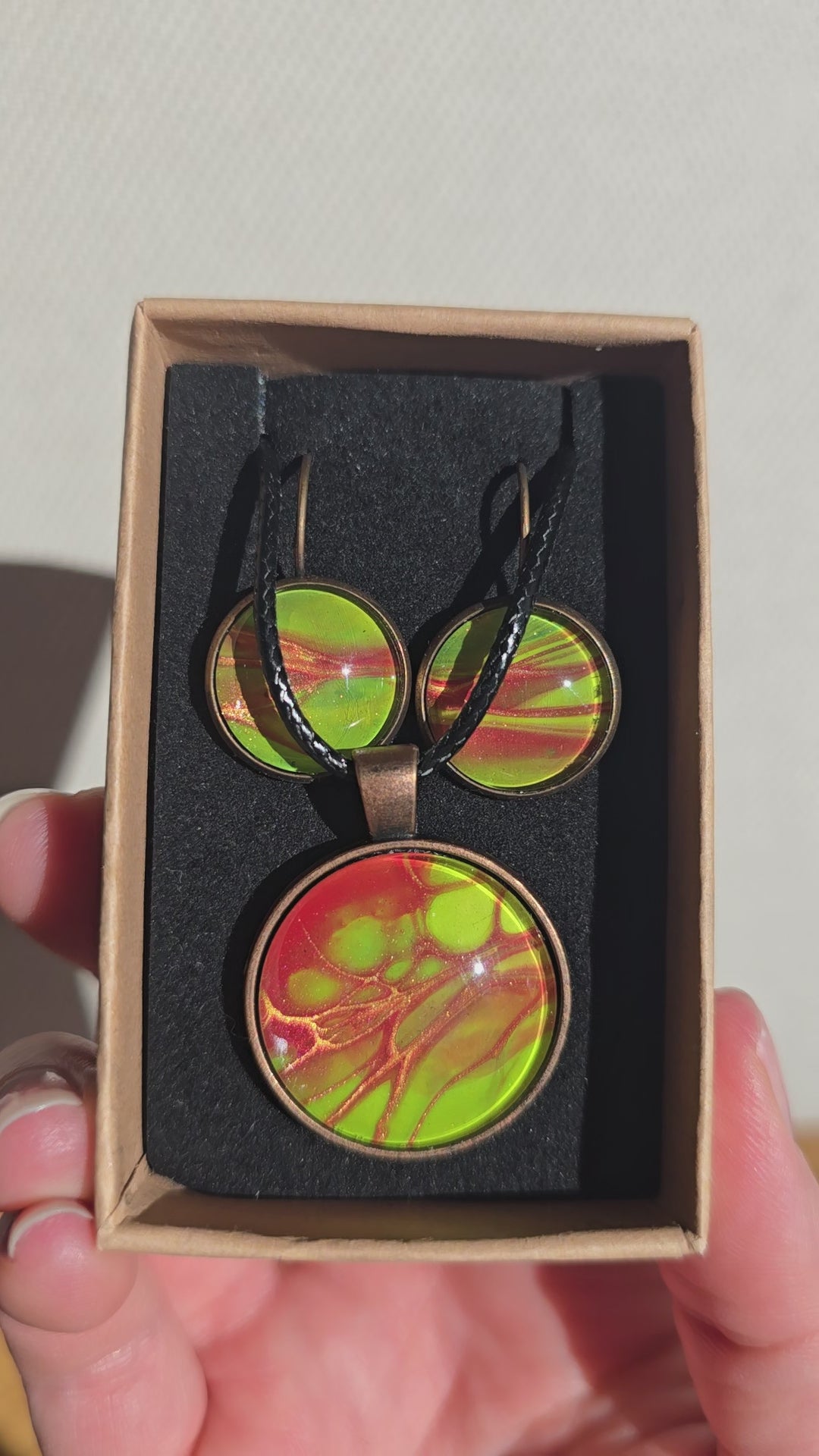 Rundes Cabochon-Schmuckset mit Kette und zwei Ohrringen in leuchtendem Grün, Korallrot und Orange, mit feinen kupferfarbenen, organischen Linien.