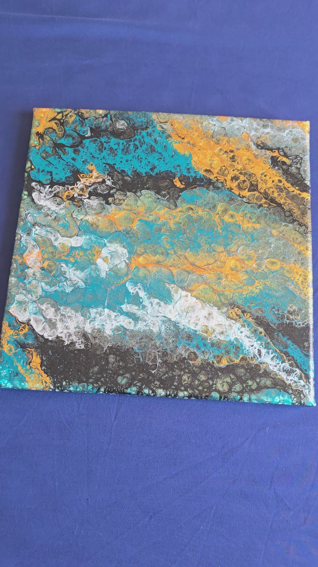 Quadratisches abstraktes Acryl-Leinwandbild mit fliessenden Zellstrukturen in Türkis, Blau, Gold, Schwarz und Weiss.