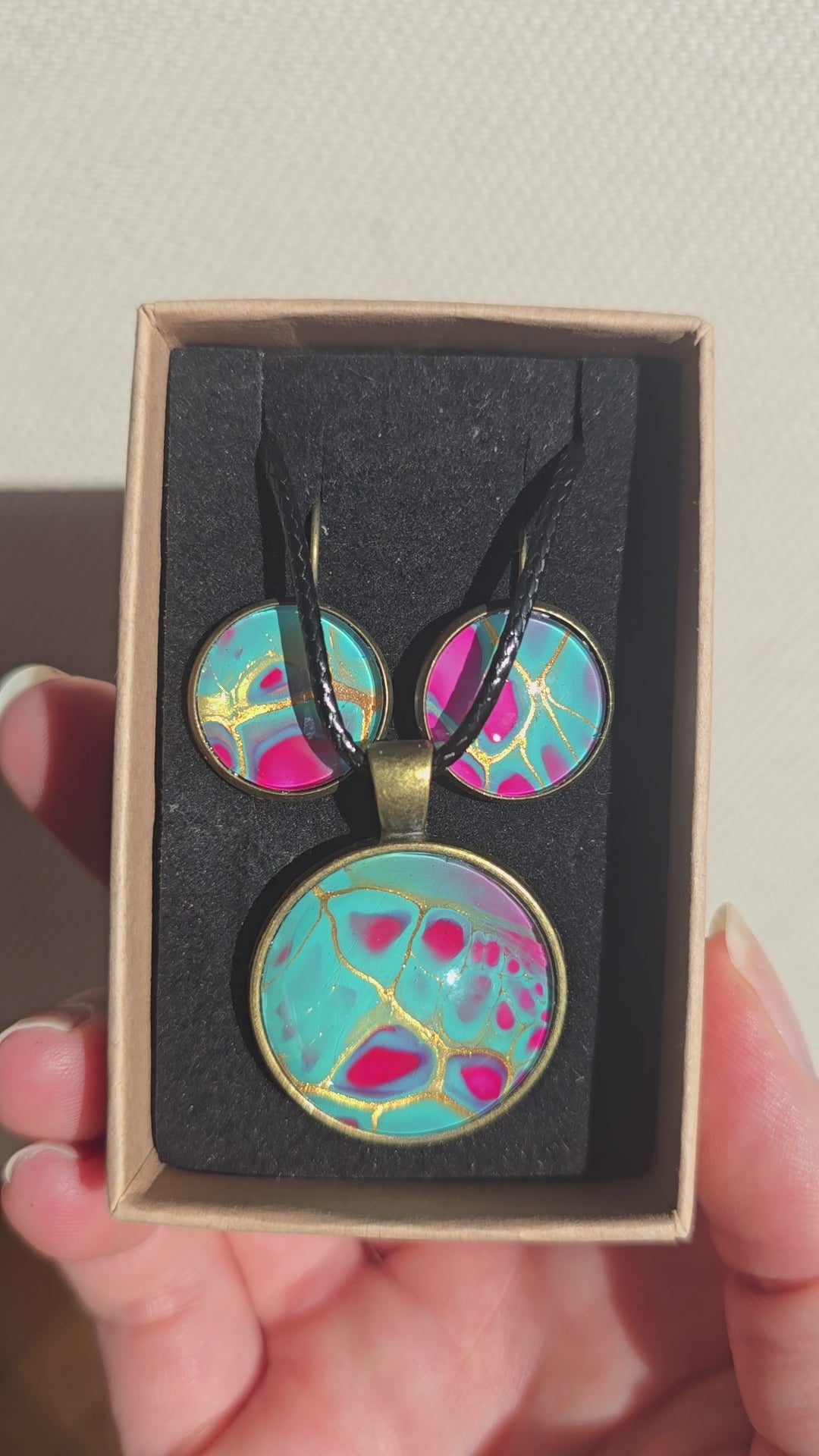 Rundes Cabochon-Schmuckset mit Halskettenanhänger und passenden Ohrringen in Türkis und kräftigem Pink mit feinen goldenen Linien.