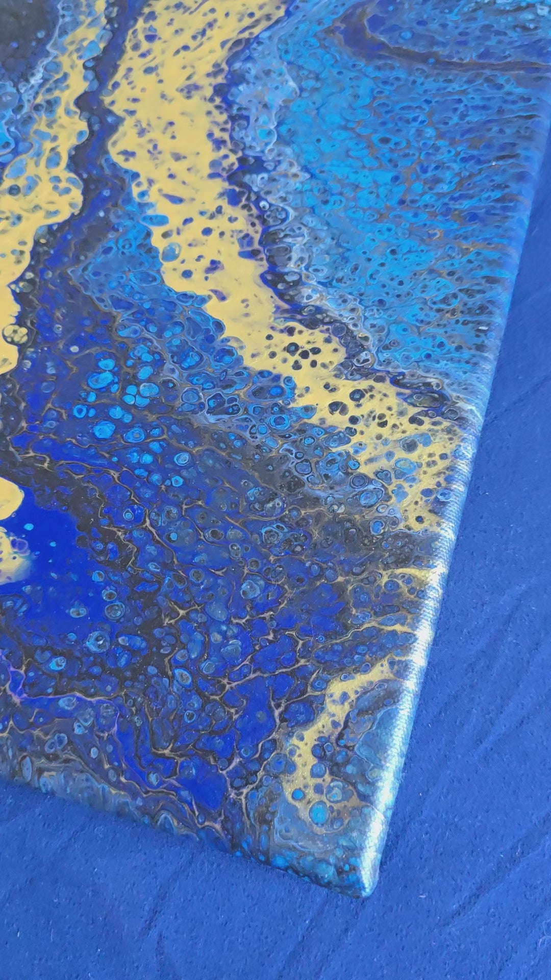 Quadratisches abstraktes Leinwandbild in kräftigem Blau, Dunkelblau und Schwarz mit grossen goldenen Flächen und feinen Zellstrukturen.
