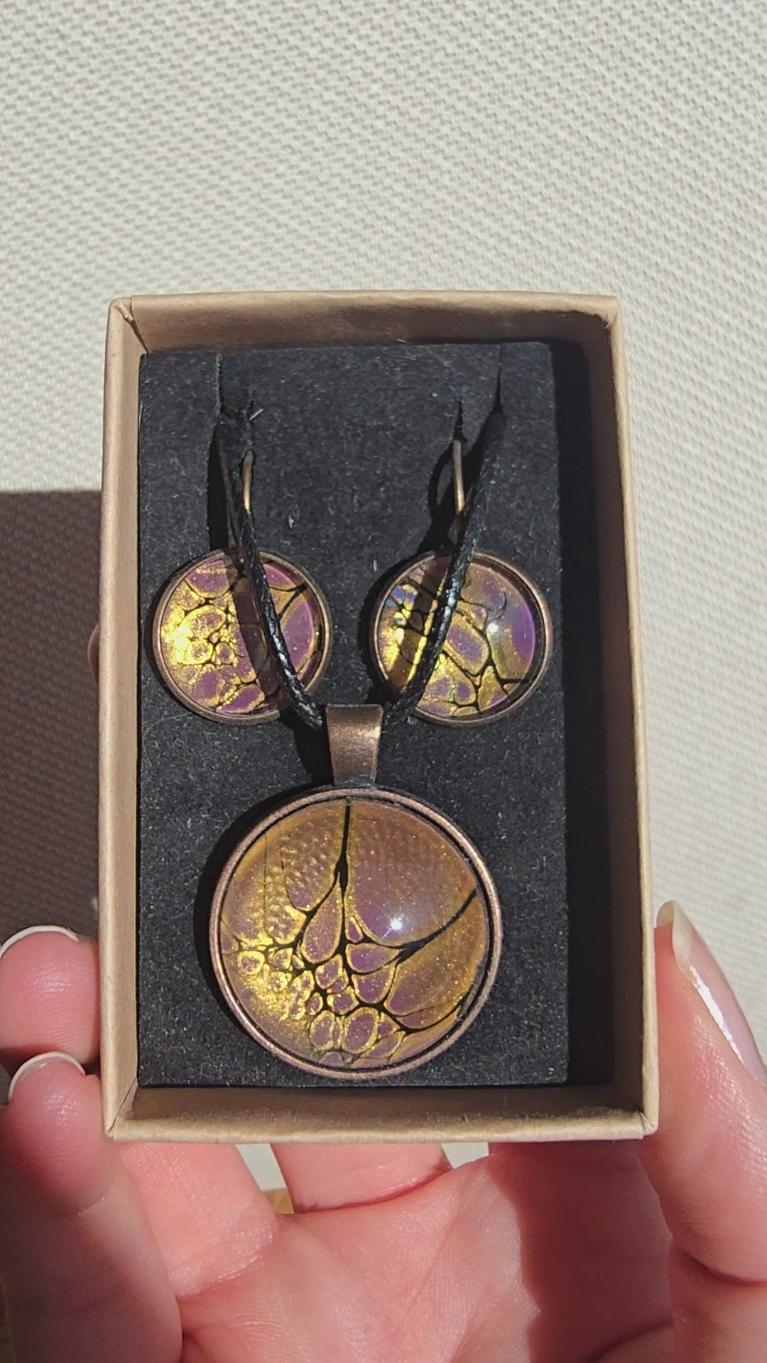 Handgefertigtes Schmuckset Solas Aurelia mit runder Halskette und passenden Ohrringen in Gold-, Violett- und Lavendeltönen mit organischer Marmorierung.