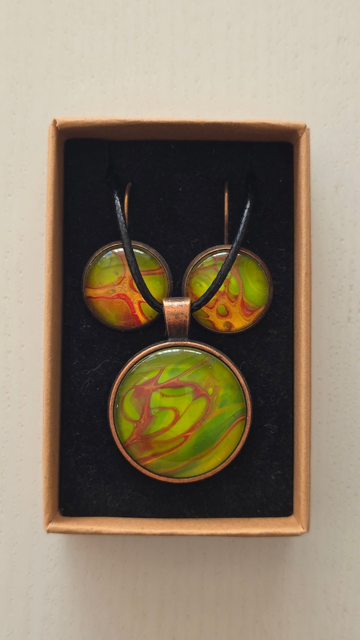 Rundes Cabochon-Schmuckset mit Kette und passenden Ohrringen, leuchtend grün mit fliessenden roten, kupferfarbenen und orangefarbenen Strukturen.