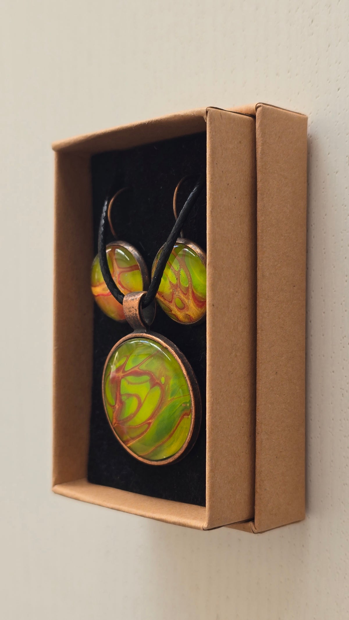 Rundes Cabochon-Schmuckset mit Kette und passenden Ohrringen, leuchtend grün mit fliessenden roten, kupferfarbenen und orangefarbenen Strukturen.