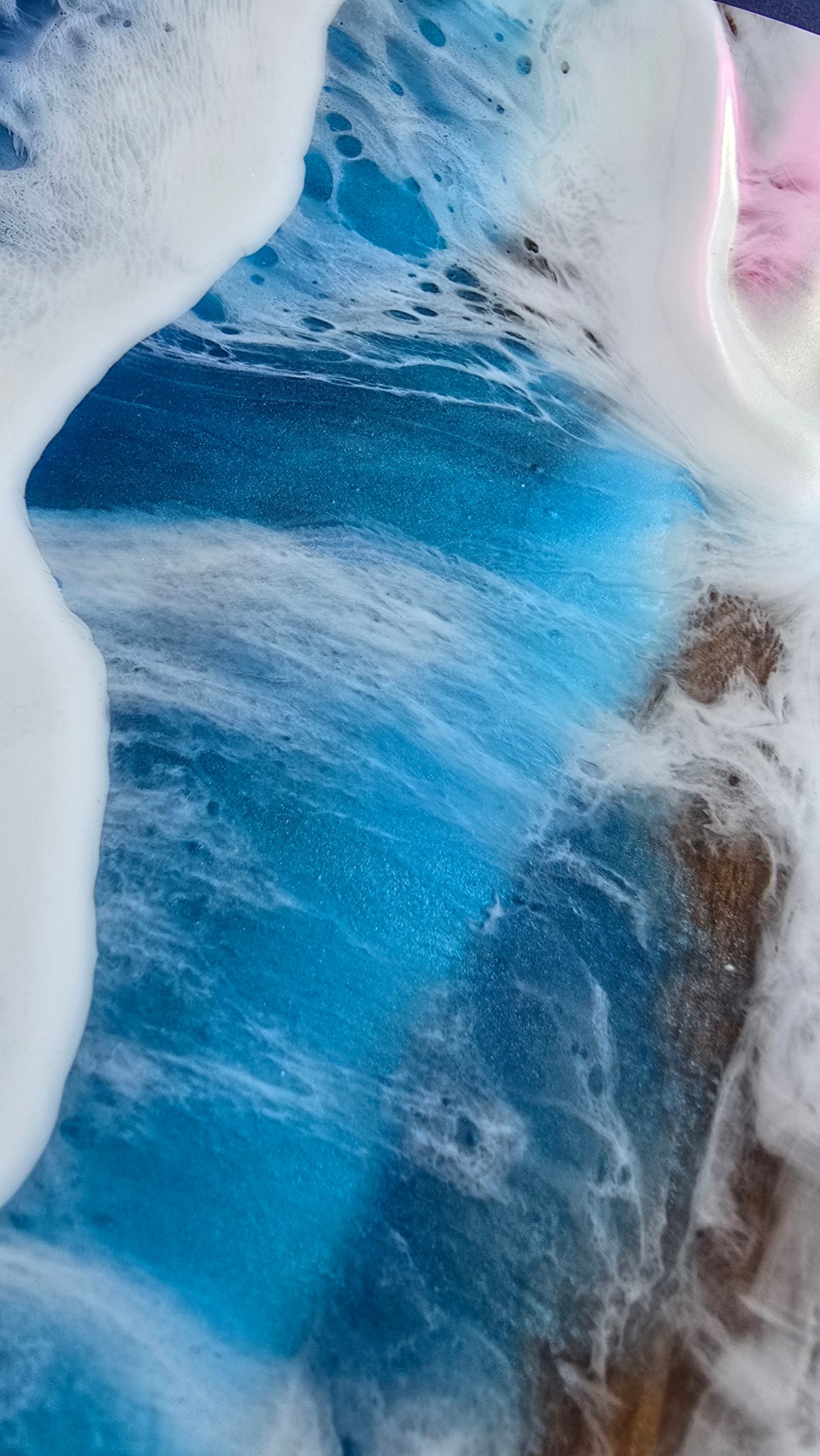 Rundes Resin Wandbild Solas Seafoam auf Holz mit blau-türkisem Meer, weissen Wellen, irisierenden Farbakzenten und sichtbarer Holzstruktur.