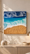 Handgefertigtes Resin-Meeresbild «Solas Shoreline» mit türkisfarbenem Wasser, schäumender Brandung und strukturiertem goldenen Strand auf einem 40 × 40 cm Gesso-Rahmen.