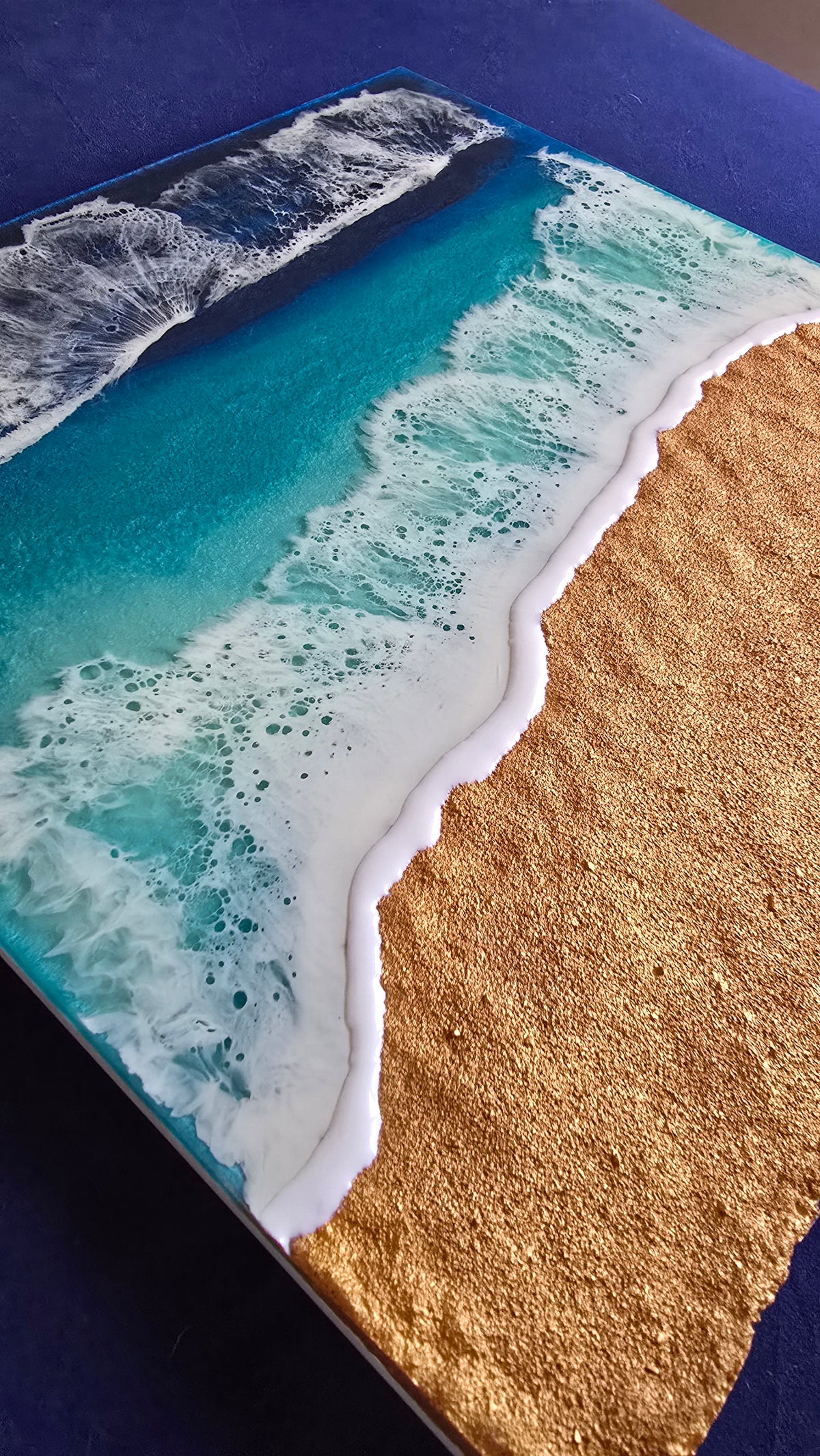 Handgefertigtes Resin-Meeresbild «Solas Shoreline» mit türkisfarbenem Wasser, schäumender Brandung und strukturiertem goldenen Strand auf einem 40 × 40 cm Gesso-Rahmen.