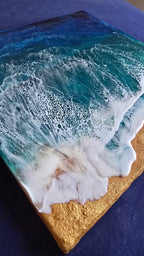 Handgefertigtes Resin-Meeresbild «Solas Storm Wave» mit kraftvollen brechenden Wellen in Blau- und Türkistönen sowie einem strukturierten goldenen Strand auf einem 40 × 40 cm grossen Gesso-Rahmen.