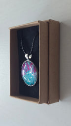 Runder Cabochon-Anhänger an schwarzem Band mit verzweigtem, organischem Muster in Türkis, Aqua, Fuchsia, Pink und hellen Linien.
