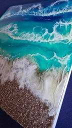 Handgefertigtes Resin-Meeresbild «Solas Turquoise Bay» mit türkisfarbenem Wasser, schäumenden Wellen und natürlichem Kieselstrand auf einem 40 × 40 cm grossen Gesso-Rahmen.