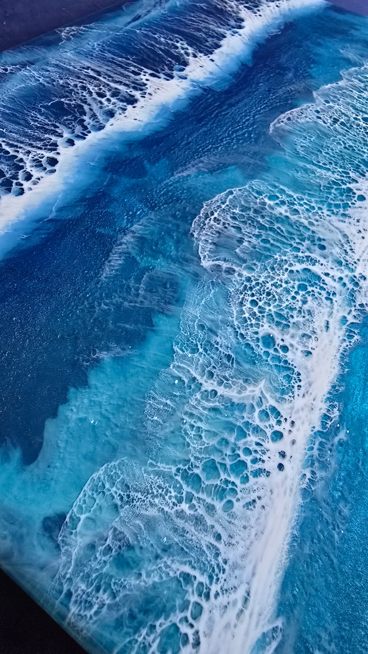 Handgefertigtes Resin-Meeresbild Solas Wild Tide (40 × 40 cm) auf einem strukturierten Gesso-Rahmen mit kraftvollen türkisblauen Wellen, natürlichem Sandstrand und schimmernden Perlmutt-Effekten.