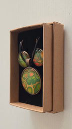Rundes Cabochon-Schmuckset mit Kette und passenden Ohrringen in verschiedenen Grüntönen, mit orangefarbenen Akzenten und feinen kupferfarbenen Linien.
